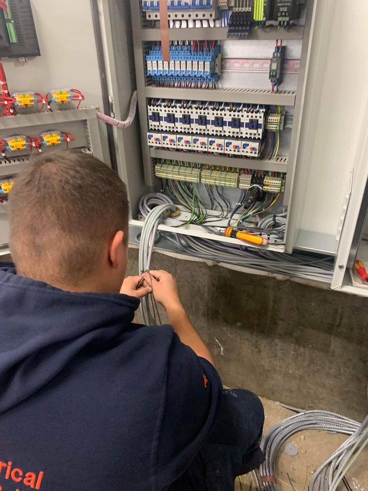 GDL engineer terminating cables in a motor control panel fitted with contactors and relays